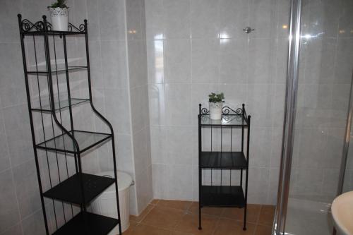bagno con doccia e 2 ripiani neri di Apartment Orzola Vista Mar a Órzola