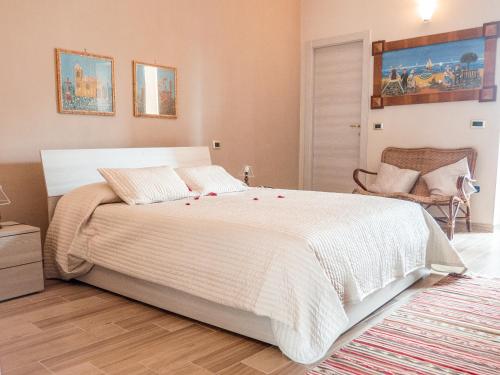 um quarto com uma cama branca com rosas vermelhas em B&b A casa di Maybe em Caserta