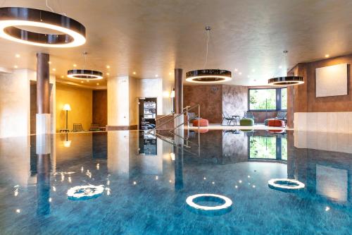 una hall con una grande piscina di acqua blu di Hotel Bergland All Inclusive Top Quality a Seefeld in Tirol