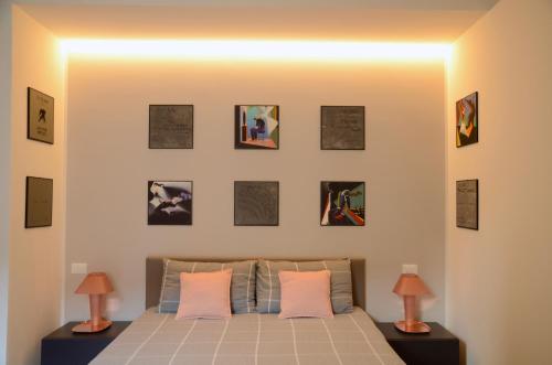 Schlafzimmer mit einem Bett mit Bildern an der Wand in der Unterkunft My Home in Bologna - La Grassa in Bologna