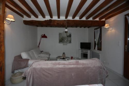 ein Wohnzimmer mit einem Bett und einem Sofa in der Unterkunft Le Clos des Hortensias in Toutainville