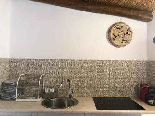 a kitchen with a sink and a plate on the wall at Ogliastra Luxury Apartment in Tortolì