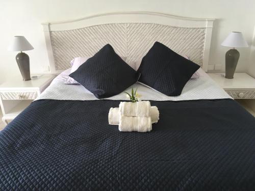 - un lit avec 2 oreillers et une plante dans l'établissement Résidence de la Vieille Tour, au Gosier