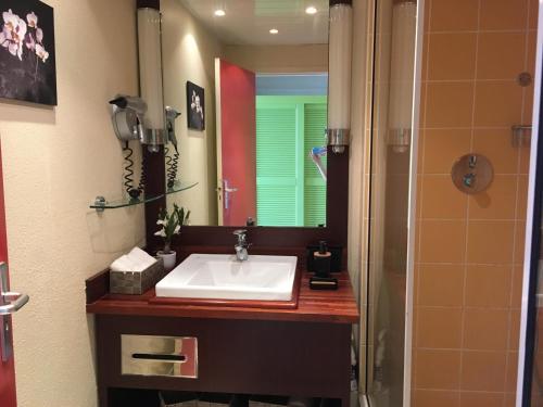 La salle de bains est pourvue d'un lavabo et d'un miroir. dans l'établissement Résidence de la Vieille Tour, au Gosier