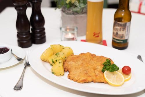a plate of food with fish and potatoes on a table at Gasthof Hotel Hauslwirt in Golling an der Salzach
