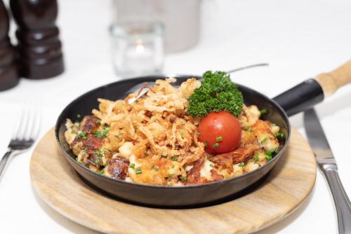 a pan of food on a table with a bowl of pasta at Gasthof Hotel Hauslwirt in Golling an der Salzach