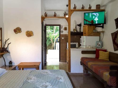 a living room with a couch and a tv at Spiros Rooms in Panormos Skopelos