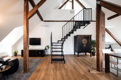 uma sala de estar com uma escada em espiral e uma lareira em Design-Loft und Apartment im Villenviertel em Mülheim an der Ruhr