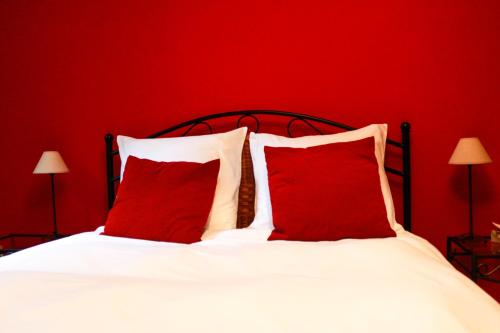een rode slaapkamer met een wit bed met rode kussens bij De Loteling in Zoersel