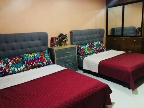 a bedroom with two beds and a dresser and mirror at Luzville Residences C10 in Naic