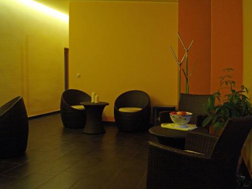 a waiting room with chairs and tables and a yellow wall at Hotel Cafe Restaurant Loreleyblick in Sankt Goar