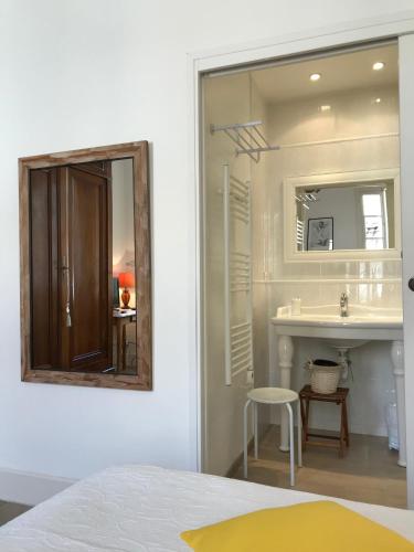une salle de bain blanche avec un miroir et un lavabo dans l'établissement Couleurs De Camargue, à Beauvoisin