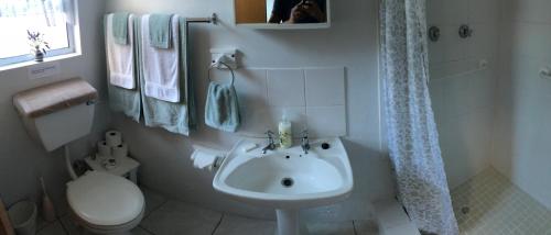 a white bathroom with a sink and a toilet at Casa Oma in Fisherhaven
