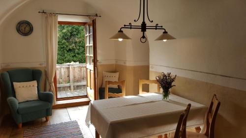 a dining room with a table and a chair and a window at Landhaus Strickenmacher in Sillian