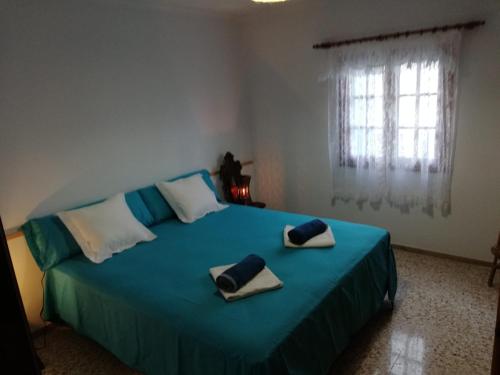una camera da letto con un grande letto blu con asciugamani di Ocean Sunshine a Órzola