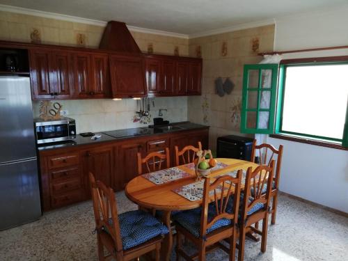 a kitchen with a wooden table with chairs and a refrigerator at Ocean Sunshine in Orzola