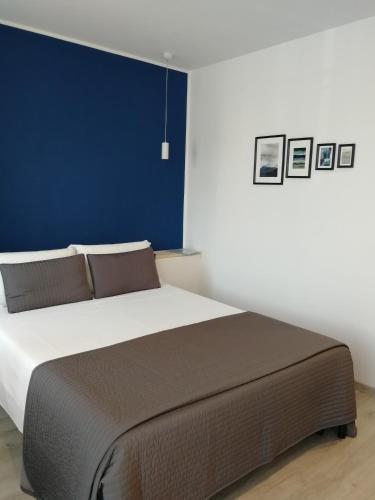 a bedroom with a large bed with a blue wall at Locazione Turistica Dal Degan in San Bonifacio