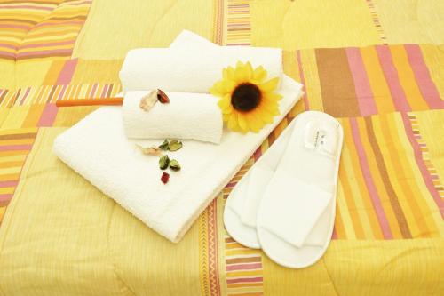 a white napkin with a sunflower on a bed at Capo d'Orlando Apartments in Capo dʼOrlando