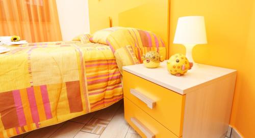 a bedroom with a bed and a table with a lamp at Capo d'Orlando Apartments in Capo dʼOrlando