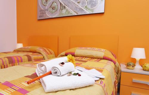 a bedroom with two beds with orange walls at Capo d'Orlando Apartments in Capo dʼOrlando