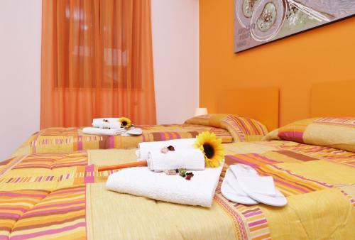 Dos camas con toallas y animales de peluche. en Capo d'Orlando Apartments, en Capo dʼOrlando
