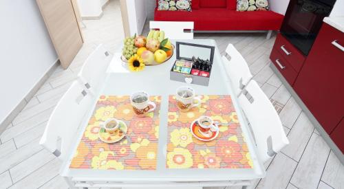 a white table with a bowl of fruit on it at Capo d'Orlando Apartments in Capo dʼOrlando