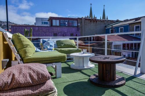 a patio with two chairs and a table on a balcony at Lemuria Hostel in Valparaíso