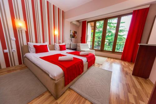 a bedroom with a large bed with a red blanket at Hotel Pine in Skopje