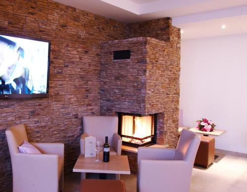 a living room with a fireplace and a tv on a brick wall at Johanneshof - Dein MOUNTAIN Wohlfühlhotel in Saalbach Hinterglemm