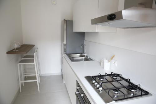 a white kitchen with a stove and a sink at Athena Design Apartment in Siracusa