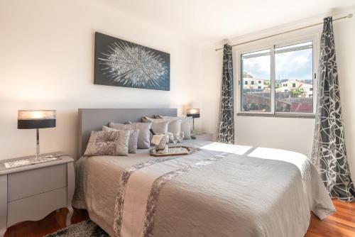 um quarto com uma cama e uma janela em Zeza´s apartament na Calheta