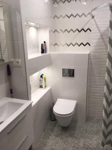 a white bathroom with a toilet and a sink at Nowy Apartament CENTRUM - faktura VAT in Włodawa