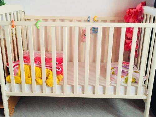 a white crib with two beds in a room at Khan Alsira - חאן אלסרה in Alsira