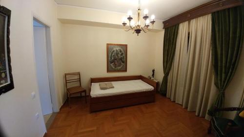 アテネにあるProteus Apartmentのベッドルーム1室(ベッド1台、シャンデリア付)
