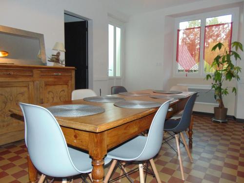 une salle à manger avec une table et des chaises en bois dans l'établissement 325 Route du Fourou, à Yzosse
