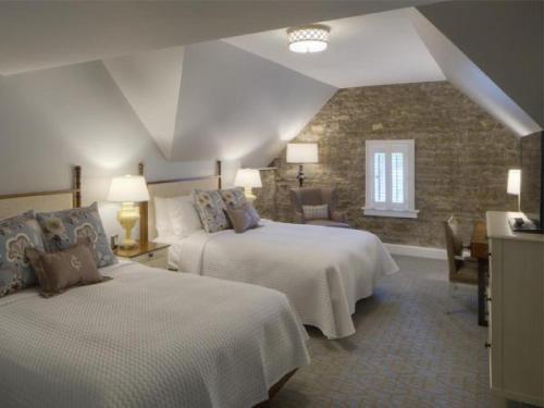 a bedroom with two beds and a stone wall at Granville Inn in Granville