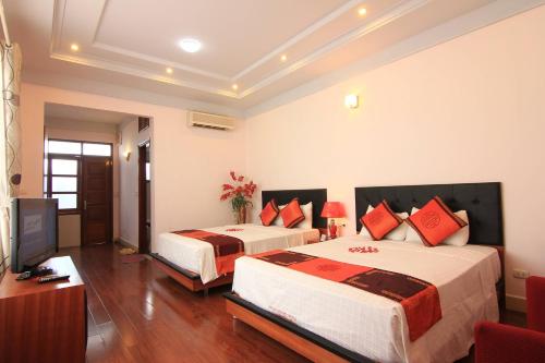 a hotel room with two beds and a television at Urban Alley Hotel in Hanoi