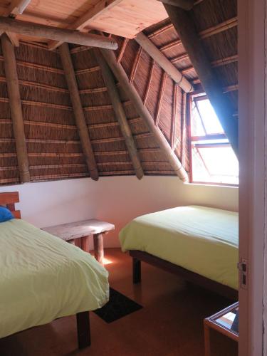 a room with two beds and a bench in it at Koensrust Sea Farm in Vermaaklikheid