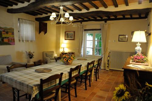 uma sala de jantar com uma mesa longa e cadeiras em Dimora delle Camelie em SantʼAndrea di Compito