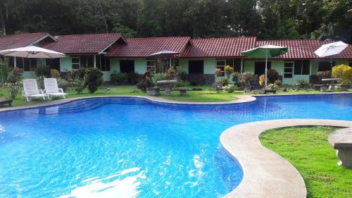 a swimming pool in front of a house at Hacienda Baru in Dominical