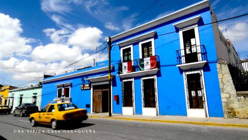 a yellow car parked in front of a blue building at Hotel Las Golondrinas in Oaxaca City