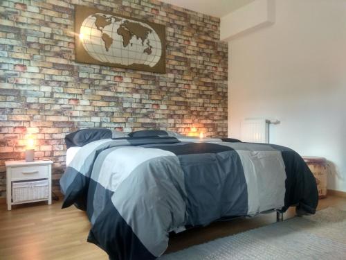 a bedroom with a bed and a brick wall at Chic apart terrace garden parking in Cergy