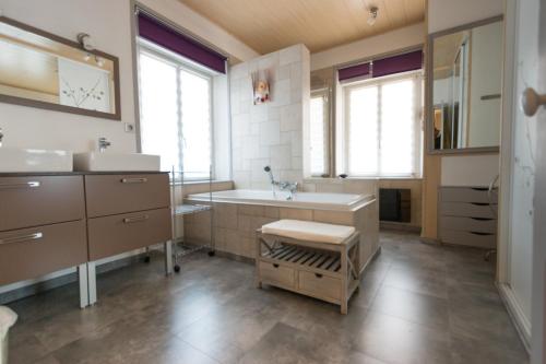 une salle de bain avec une baignoire, un lavabo et un miroir dans l'établissement Le batelier du lac, à Gérardmer