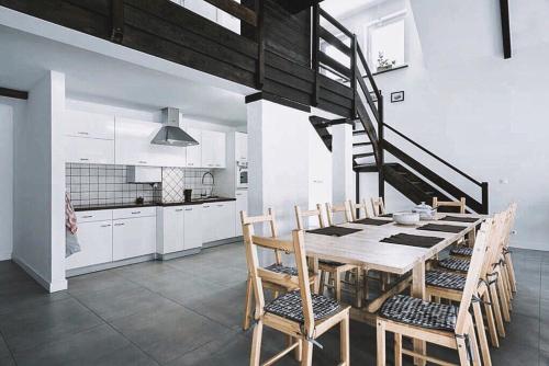 a kitchen and dining room with a wooden table and chairs at Pradnik Valley Lodge in Prądnik Korzkiewski