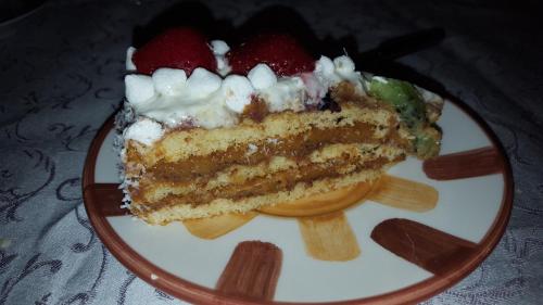 a piece of cake with strawberries on a plate at Tangohotel in Lucca