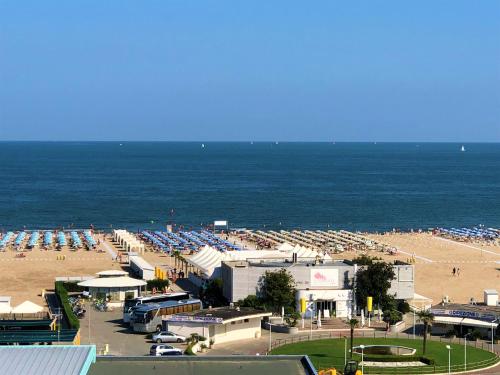 a beach with a lot of parked cars and the ocean at Hotel Bristol in Sottomarina