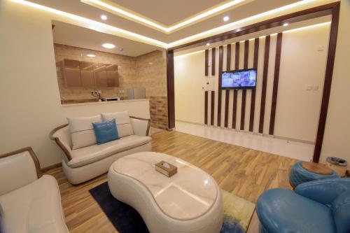 a living room with two couches and a tv at فندق جولدن نايت Golden Night Hotel in Najran