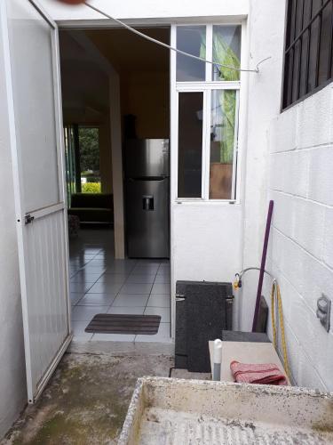 an open door of a house with a refrigerator at Punta del Sol en Temixco, Morelos in Acatlipa