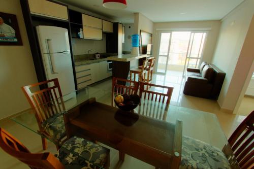 a kitchen and dining room with a table and chairs at Edificio Villa Milano in Bombinhas