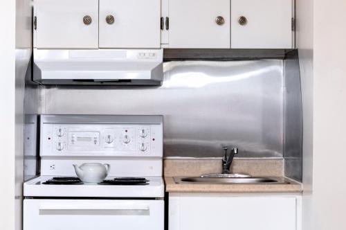a white kitchen with a sink and a stove at Mount Peyton Resort & Conference Centre in Grand Falls -Windsor